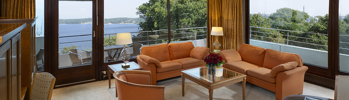 Bright living area of the presidential suite at Maritim Hotel Kiel with panoramic Baltic Sea view and stylish furniture.