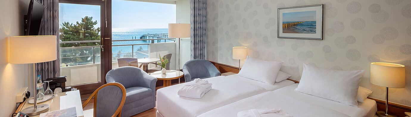 Superior room with double bed, desk, seating area and balcony overlooking the Baltic Sea