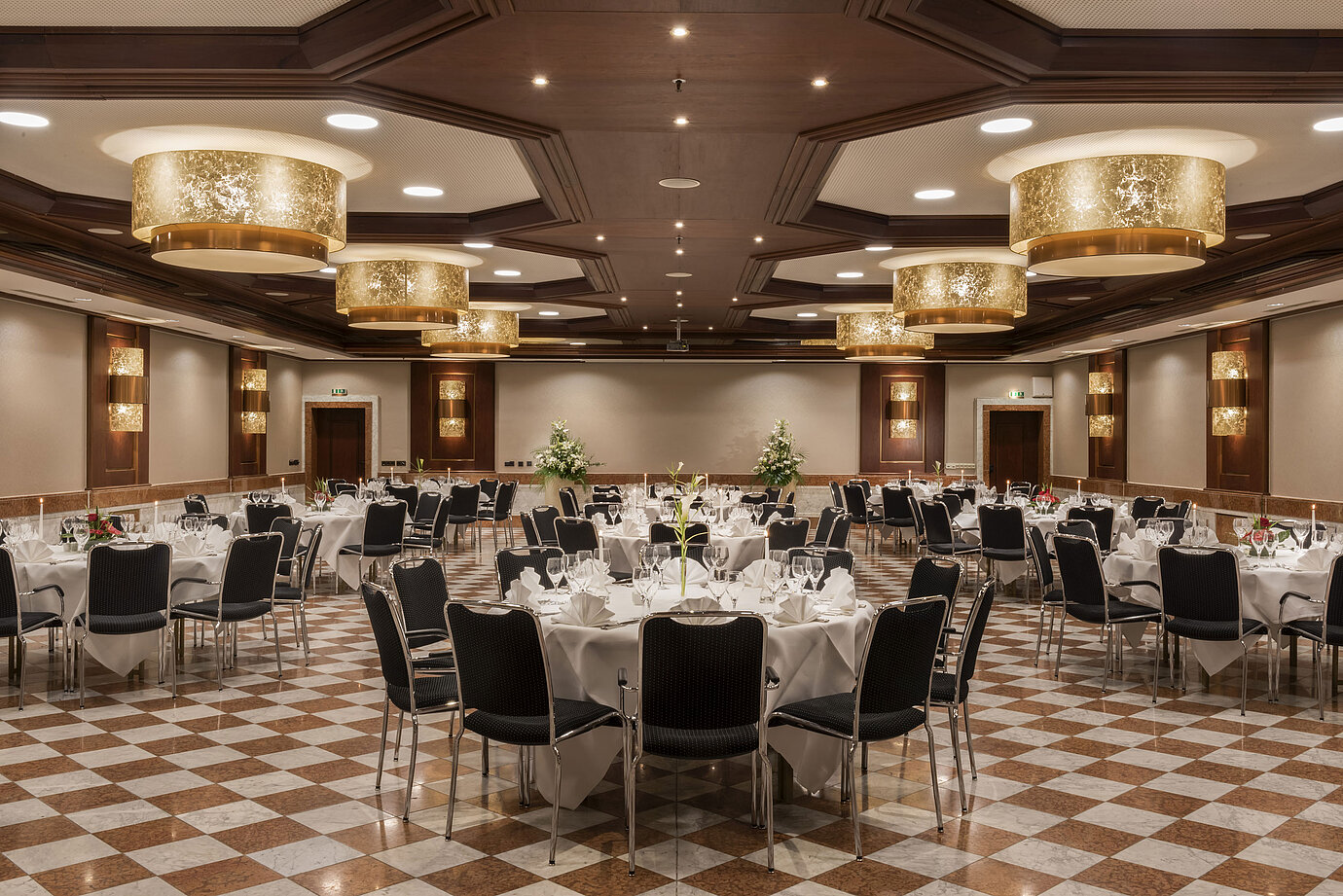 Elegant banquet hall at Maritim Hotel Königswinter with round tables, stylish decor, and chandeliers.