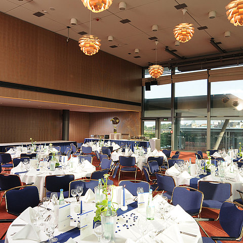 Elegant event hall in Maritim Hotel Dresden with festively set tables and a view of the city.