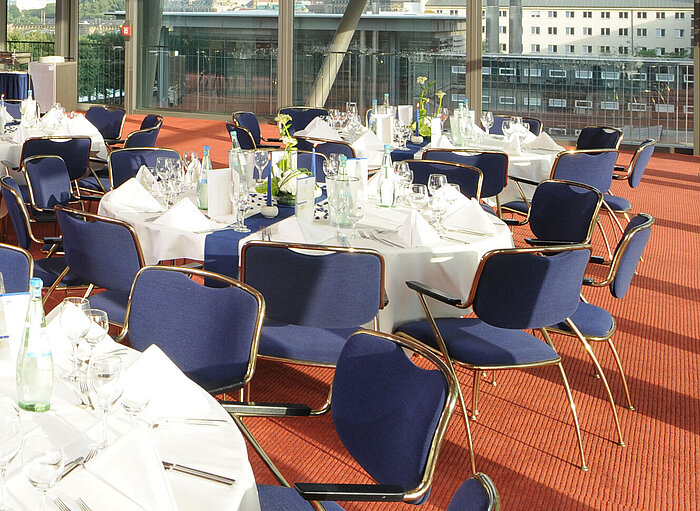 Elegant event hall in Maritim Hotel Dresden with festively set tables and a view of the city.