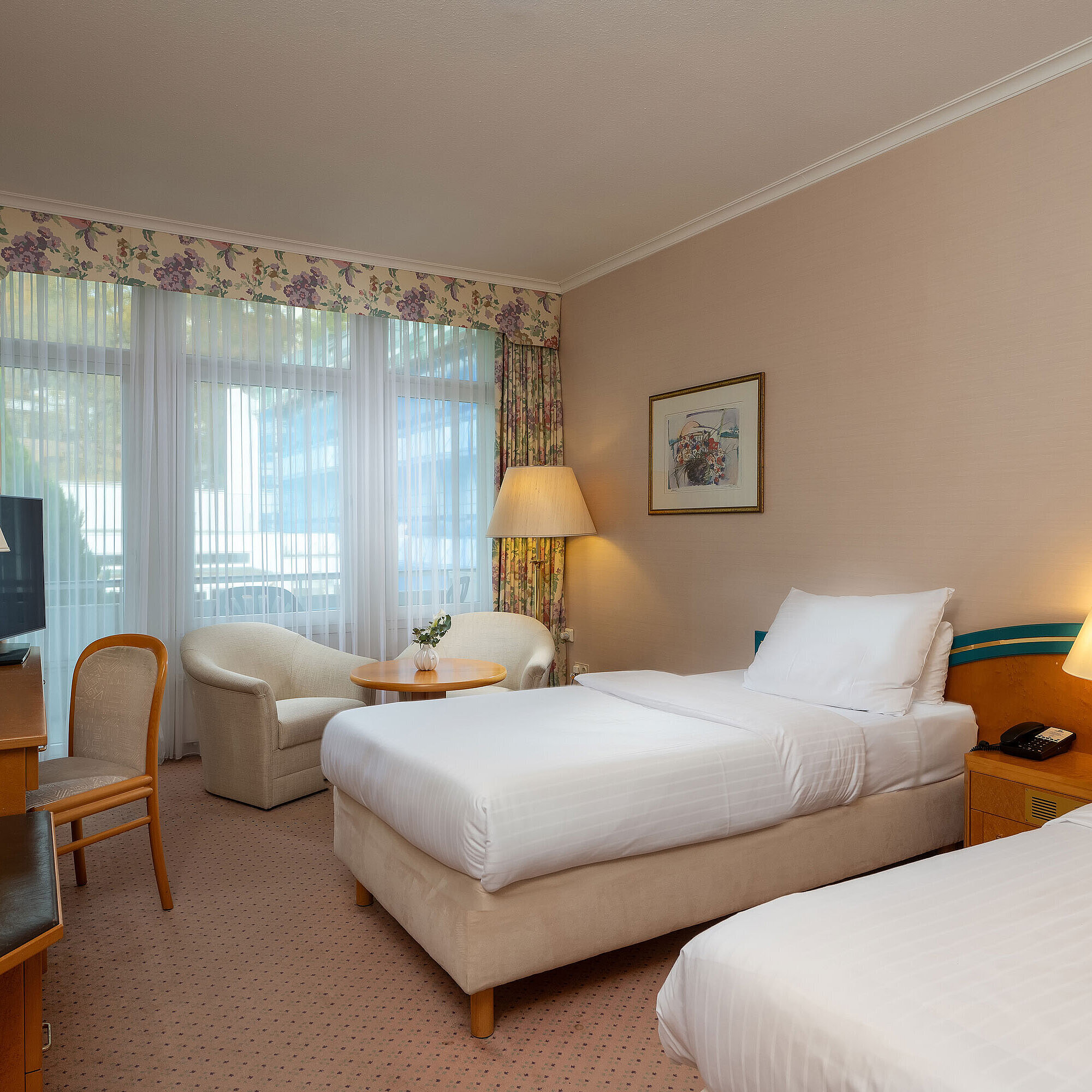 Comfort Twin room with two single beds, desk, seating area and large window for plenty of daylight.