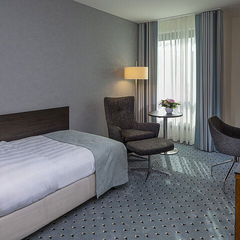 Comfortable Superior single room at Maritim Hotel Bremen with desk, armchair, and modern design.