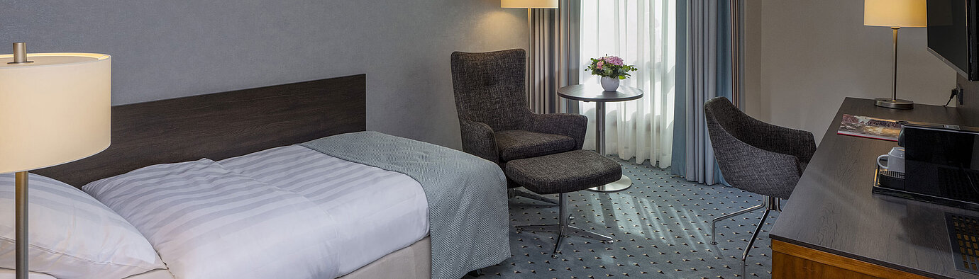 Superior room Comfortable Superior single room at Maritim Hotel Bremen with desk, armchair, and modern design.