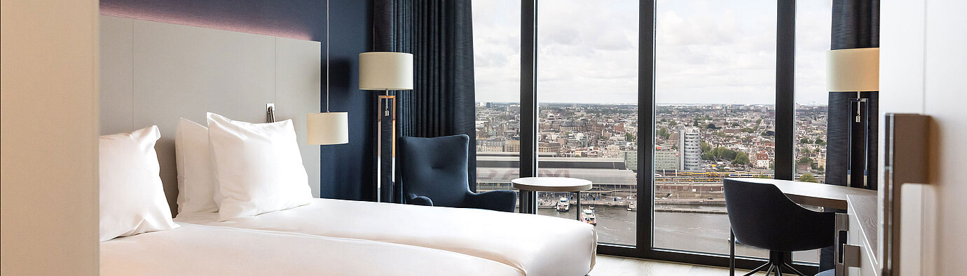 Twin room in Maritim Hotel Amsterdam with large window and panoramic city view