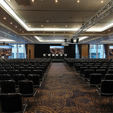 Large conference room with modern equipment and row seating at the Maritim proArte Hotel, ideal for conferences and events.