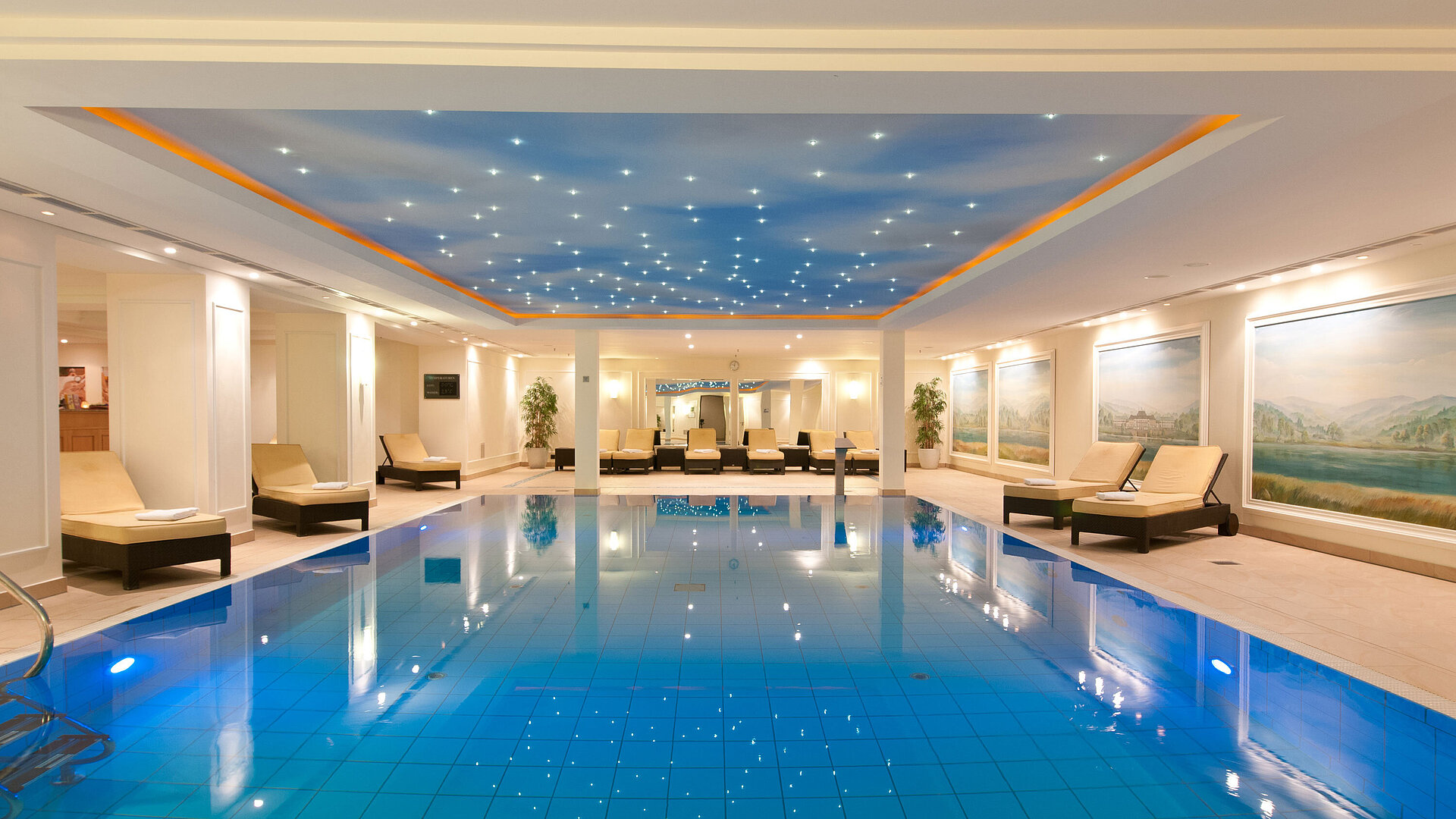 Pool Luxurious indoor pool at the Maritim Hotel Dresden with loungers and atmospheric ceiling lighting.
