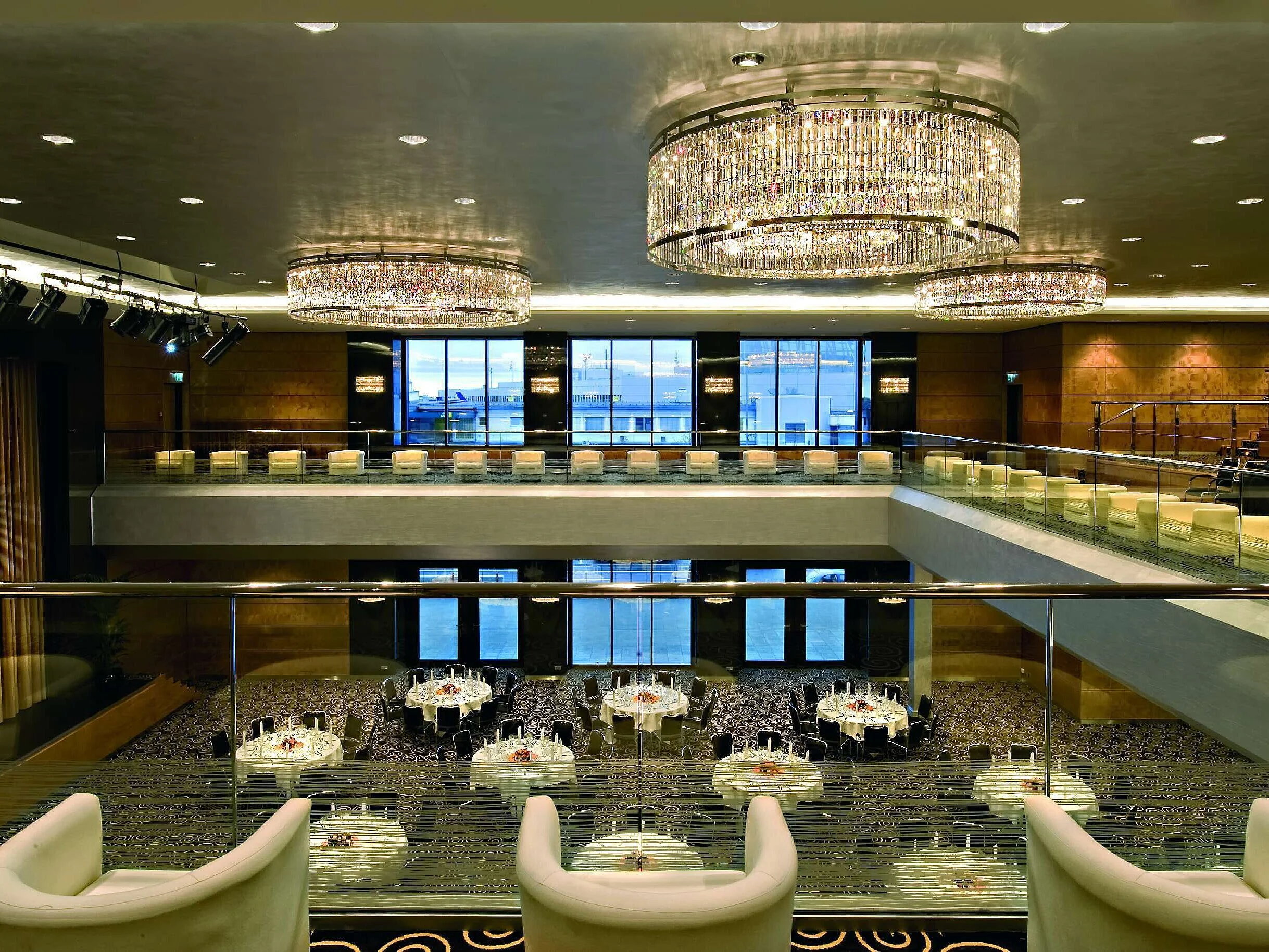 Elegant hall at Maritim Hotel Düsseldorf with impressive chandeliers, modern architecture, and a large stage.