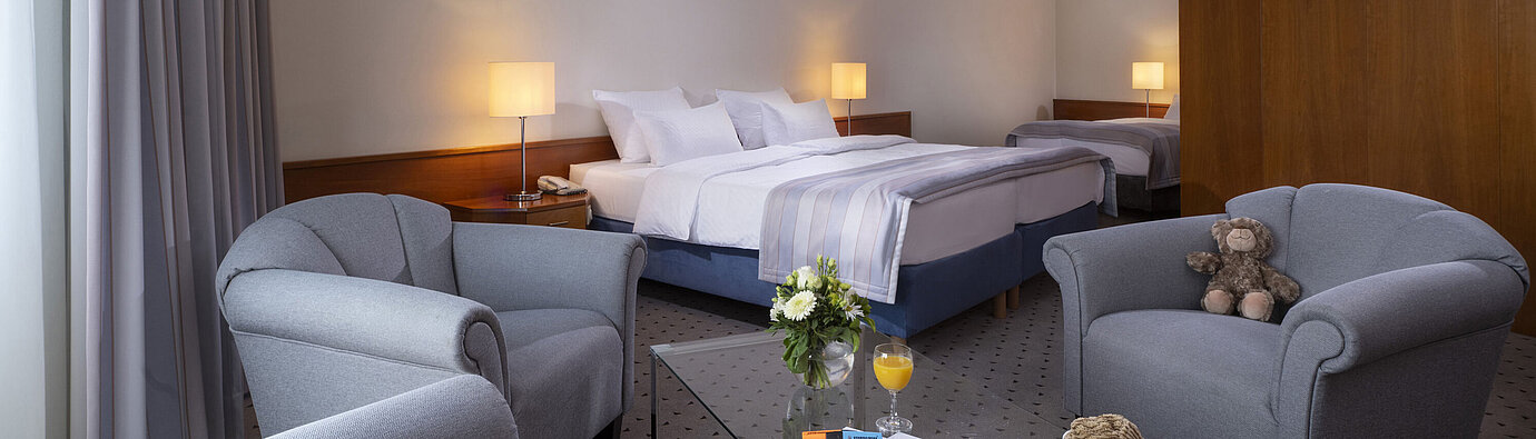 Superior Family room Family room at Maritim Hotel Hannover with double bed, single bed, seating area and lovely details.