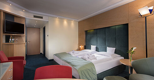 Superior room at Maritim proArte Hotel Berlin featuring a double bed, seating area, and modern lighting.