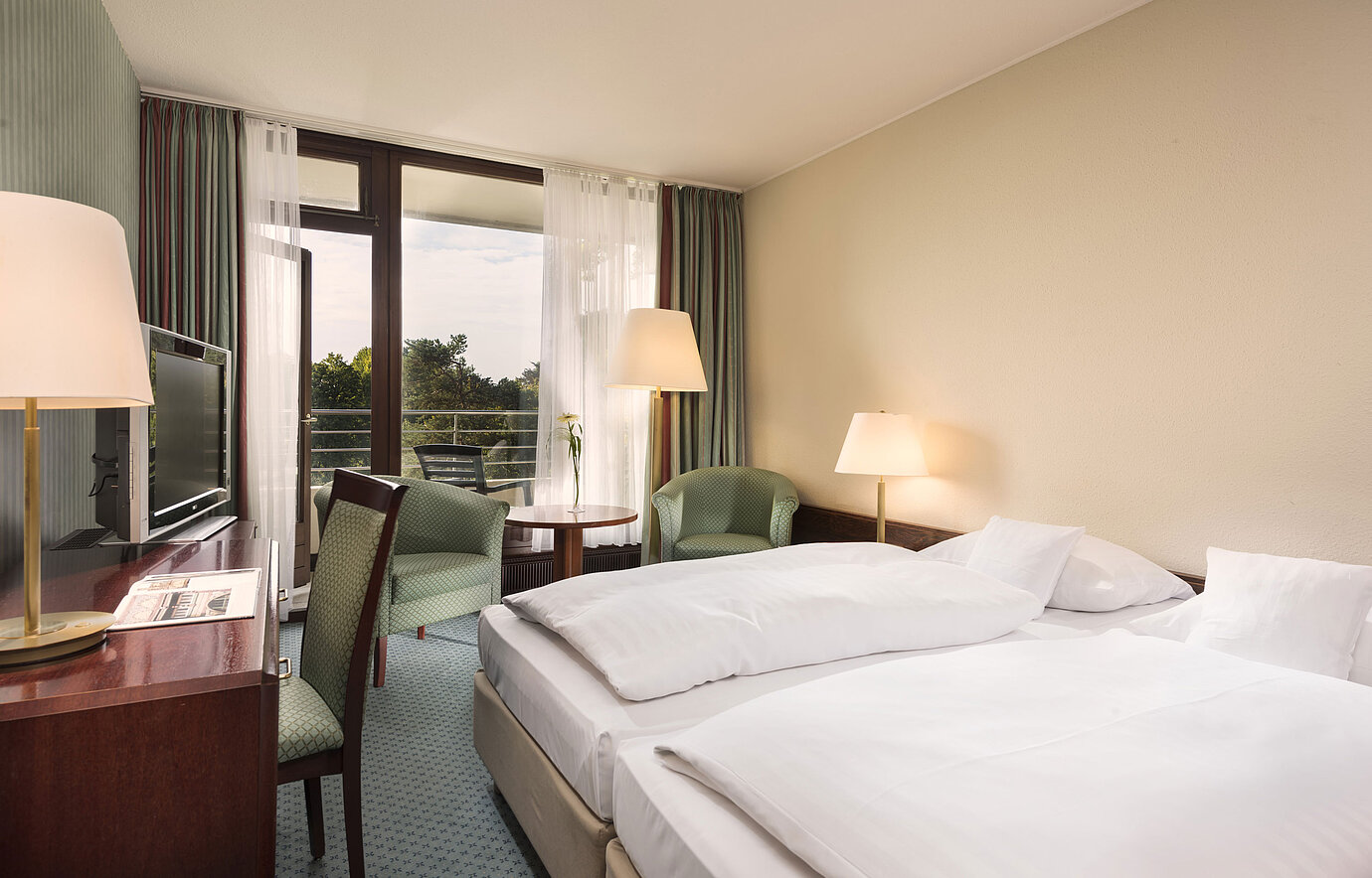 Double room with balcony, armchairs and desk at Maritim Hotel Bad Salzuflen