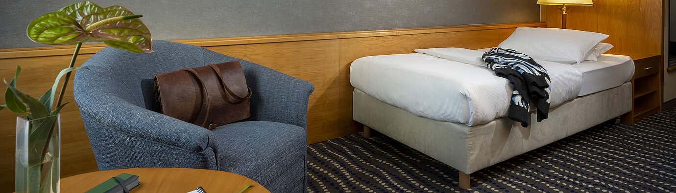 Classic single room with desk, bedside lamp, and modern wall art