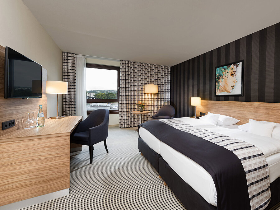 Elegant twin room at Maritim Hotel Königswinter with Rhine view, modern design, and stylish interior.
