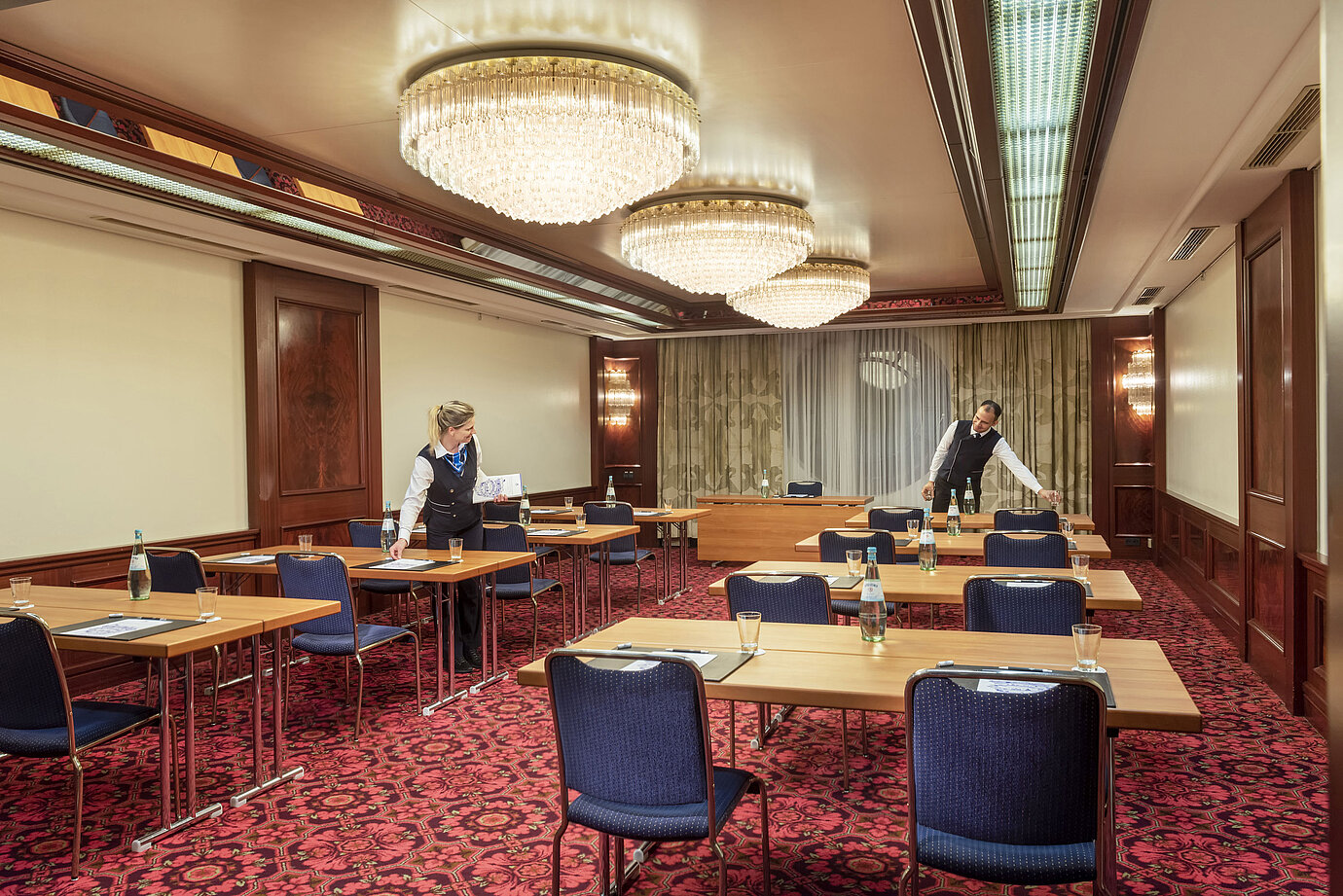 Salon Bonn at Maritim Cologne, staff preparing the room with tables, water bottles, and glasses for an event.