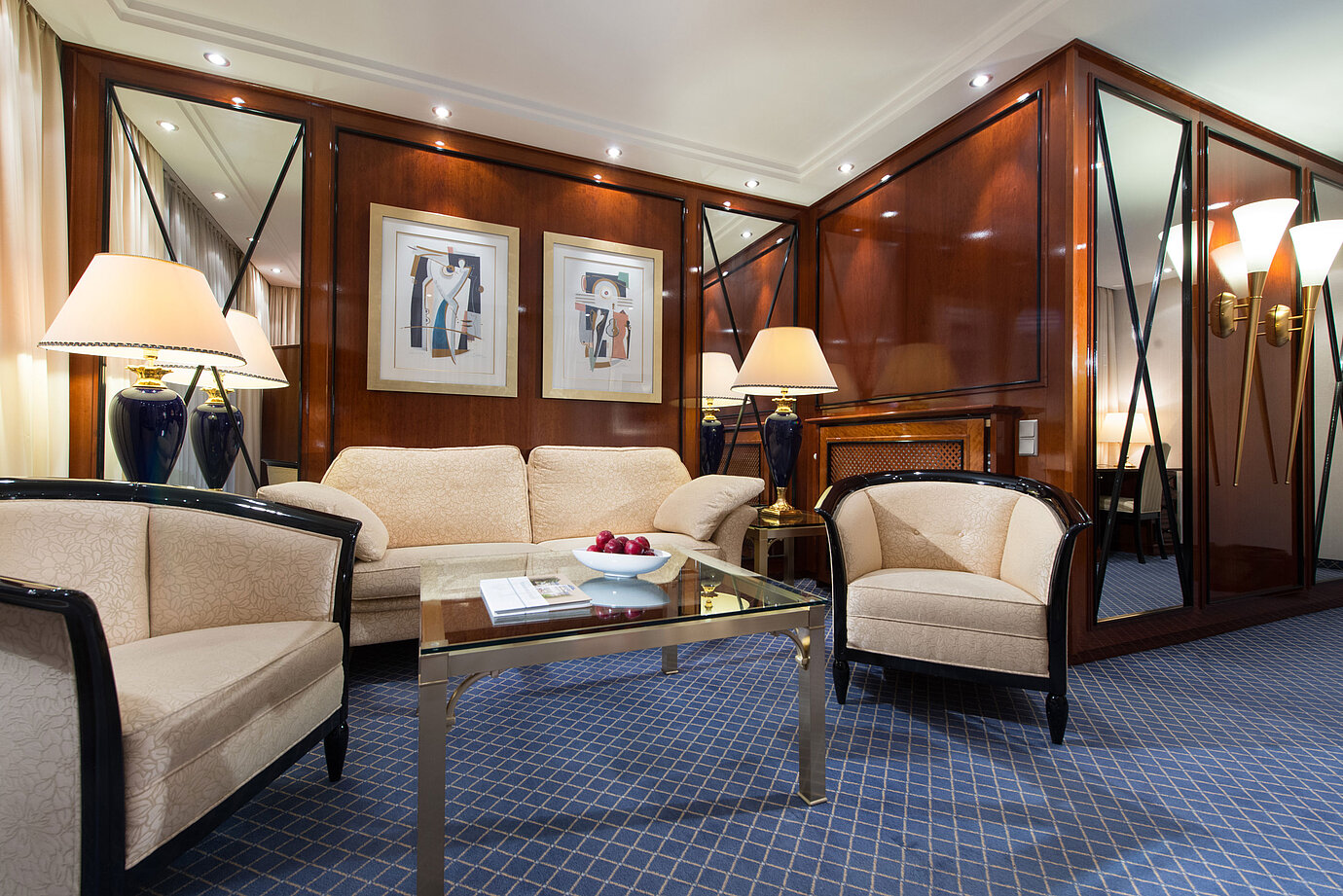 Elegant living area of a suite at Maritim Hotel Fulda with stylish furniture, glass coffee table, and cozy lighting.