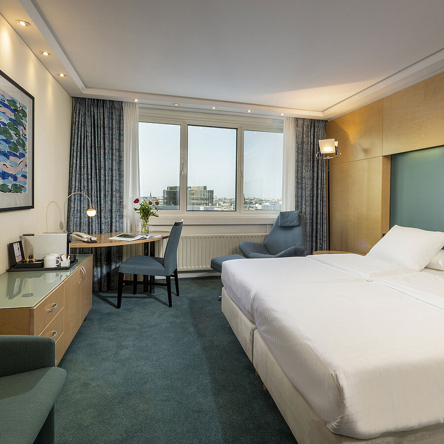 Modernly furnished Superior room at Maritim proArte Hotel Berlin with large bed, desk, artwork, and city view from the window