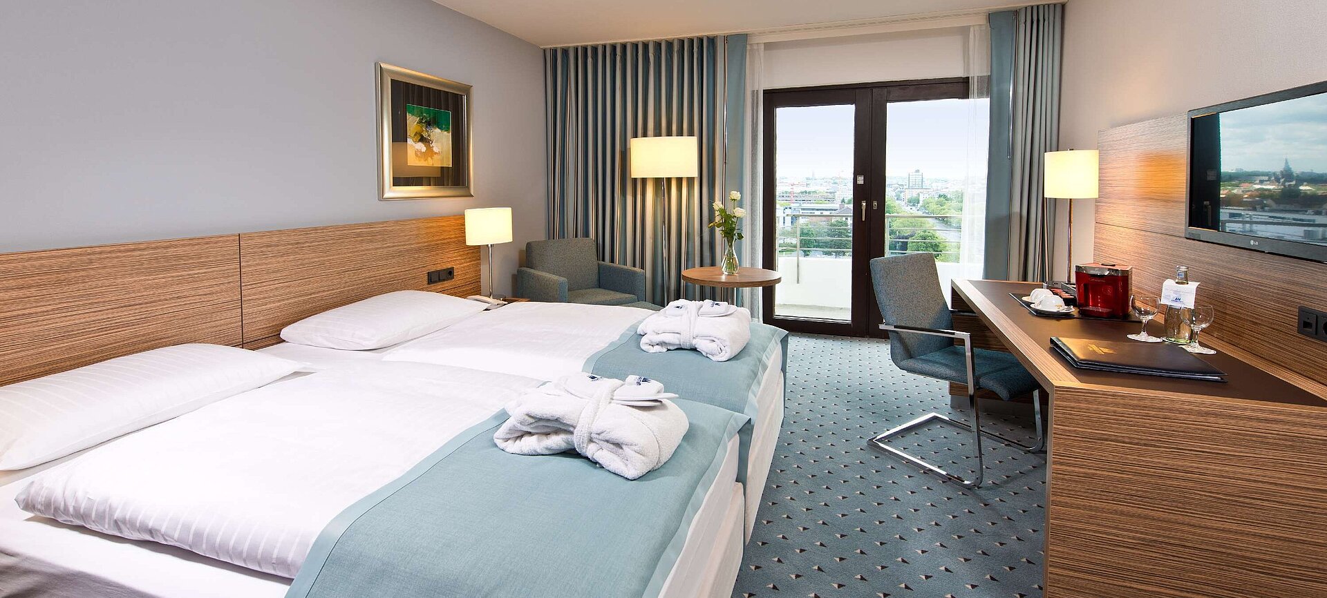 Superior room at Maritim Hotel Darmstadt featuring stylish design, desk, cozy seating area, and double bed with bathrobes.