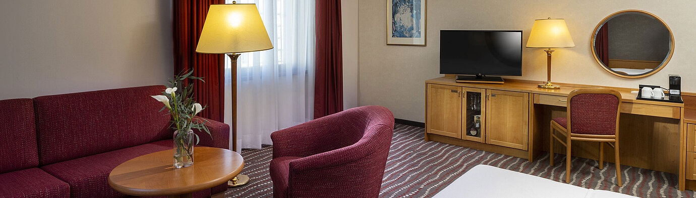 Studio Comfortable studio room at the Maritim Hotel Magdeburg with seating area, desk, and modern TV.
