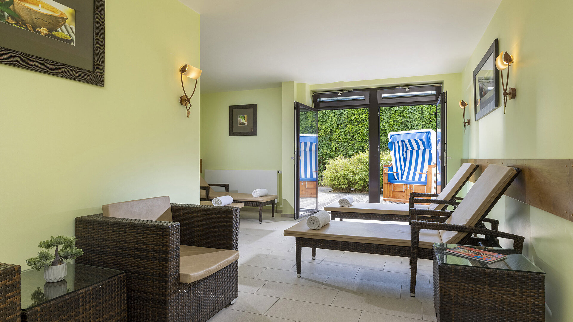 Bright relaxation room with loungers and terrace access at Maritim Hotel Travemünde
