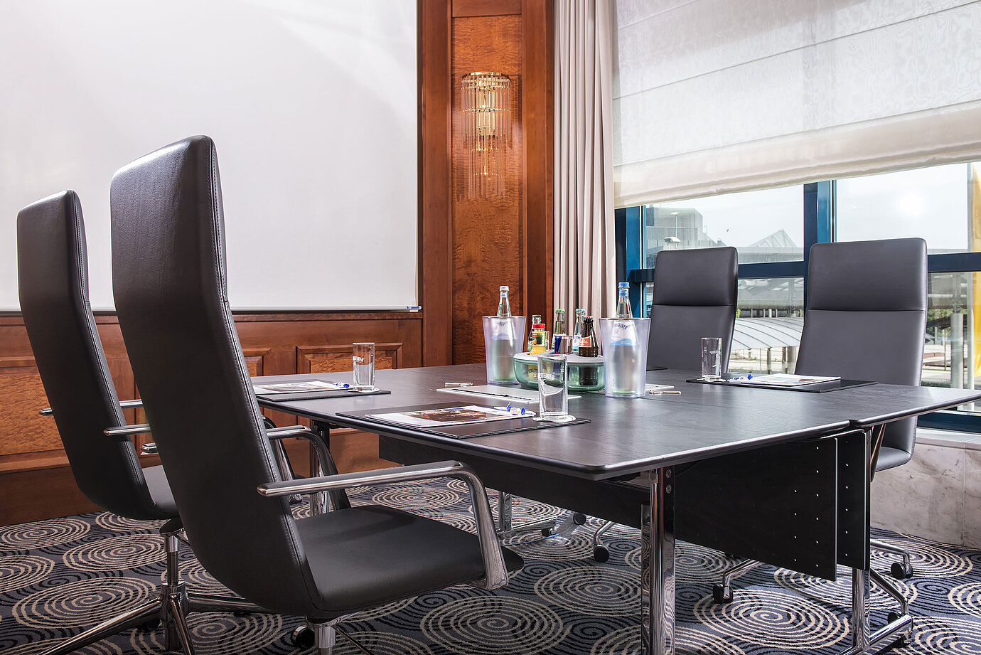 Modern meeting room with a large table, leather chairs, and natural light at Maritim Hotel Hannover.