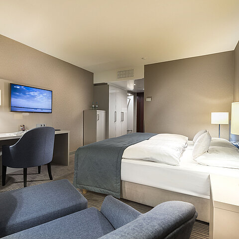 Superior room at Maritim Hotel Bonn with double bed, desk, TV, and modern decor. Comfortable and elegant.
