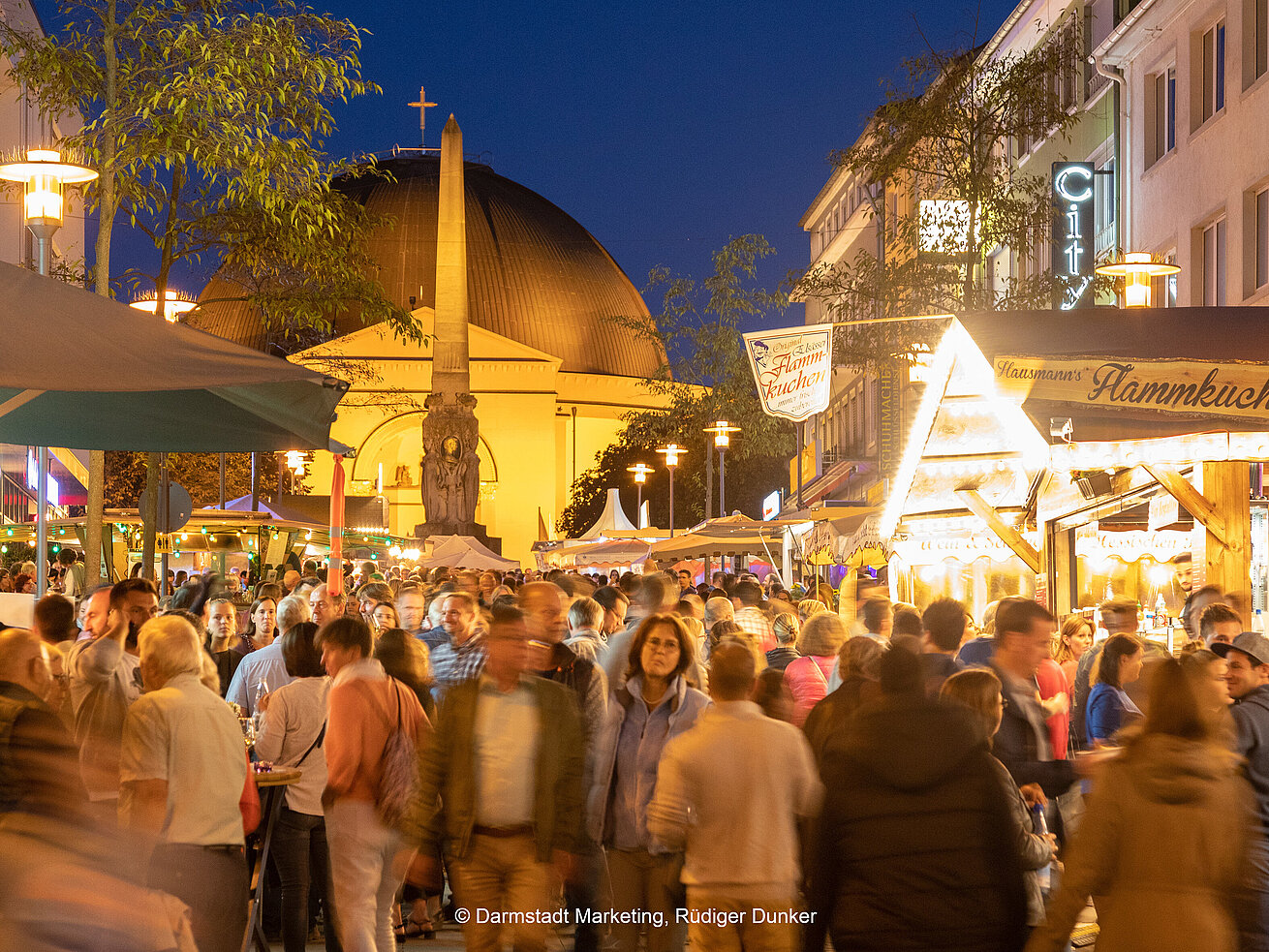 Vine festival Darmstadt Busy city festival with market stalls and church at night