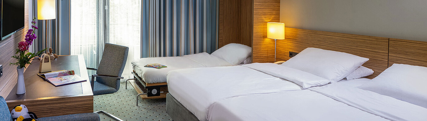 Comfort Family room at the Maritim Hotel Darmstadt with a double bed, extra bed, and modern workspace