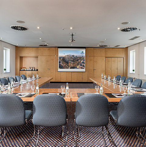 Meeting room with rectangular table setup and modern presentation technology at Maritim proArte Hotel Berlin.