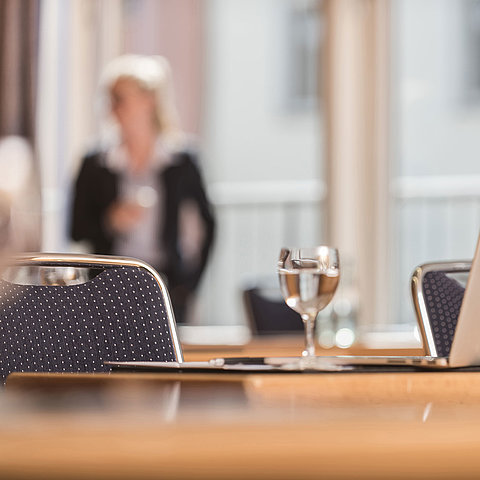 Close-up of a conference room at Maritim proArte Hotel Berlin, focusing on laptop and water glass.