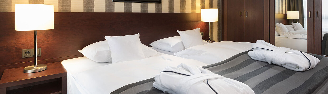 Modern double room with cozy bed, bathrobes, and stylish interior at Maritim Hotel Königswinter.