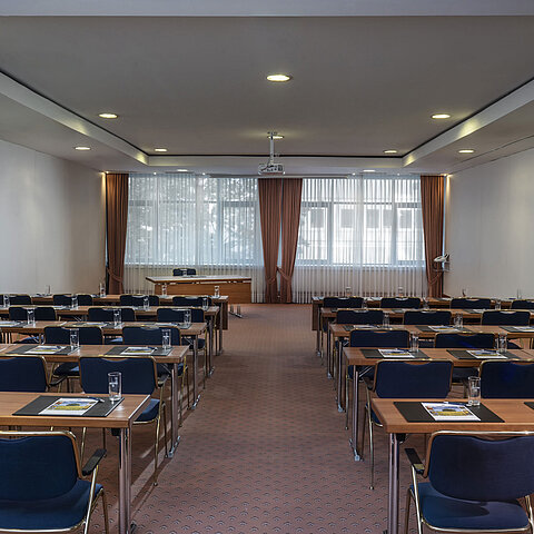 Modern meeting room at the Maritim Hotel Magdeburg with row seating, natural light, and technical equipment.