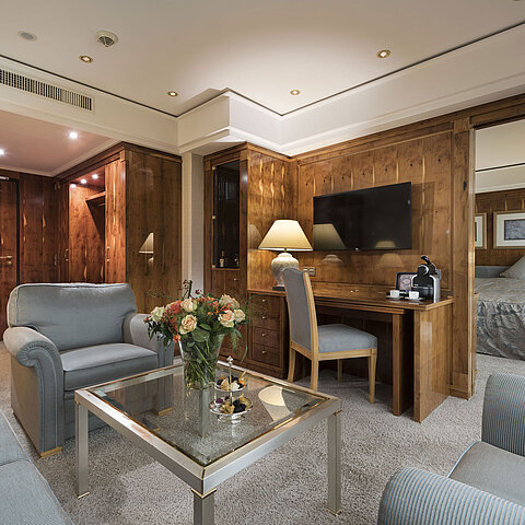 Penthouse suite with living room, wooden furniture, desk, and view into bedroom at Maritim Seehotel Timmendorfer Strand.