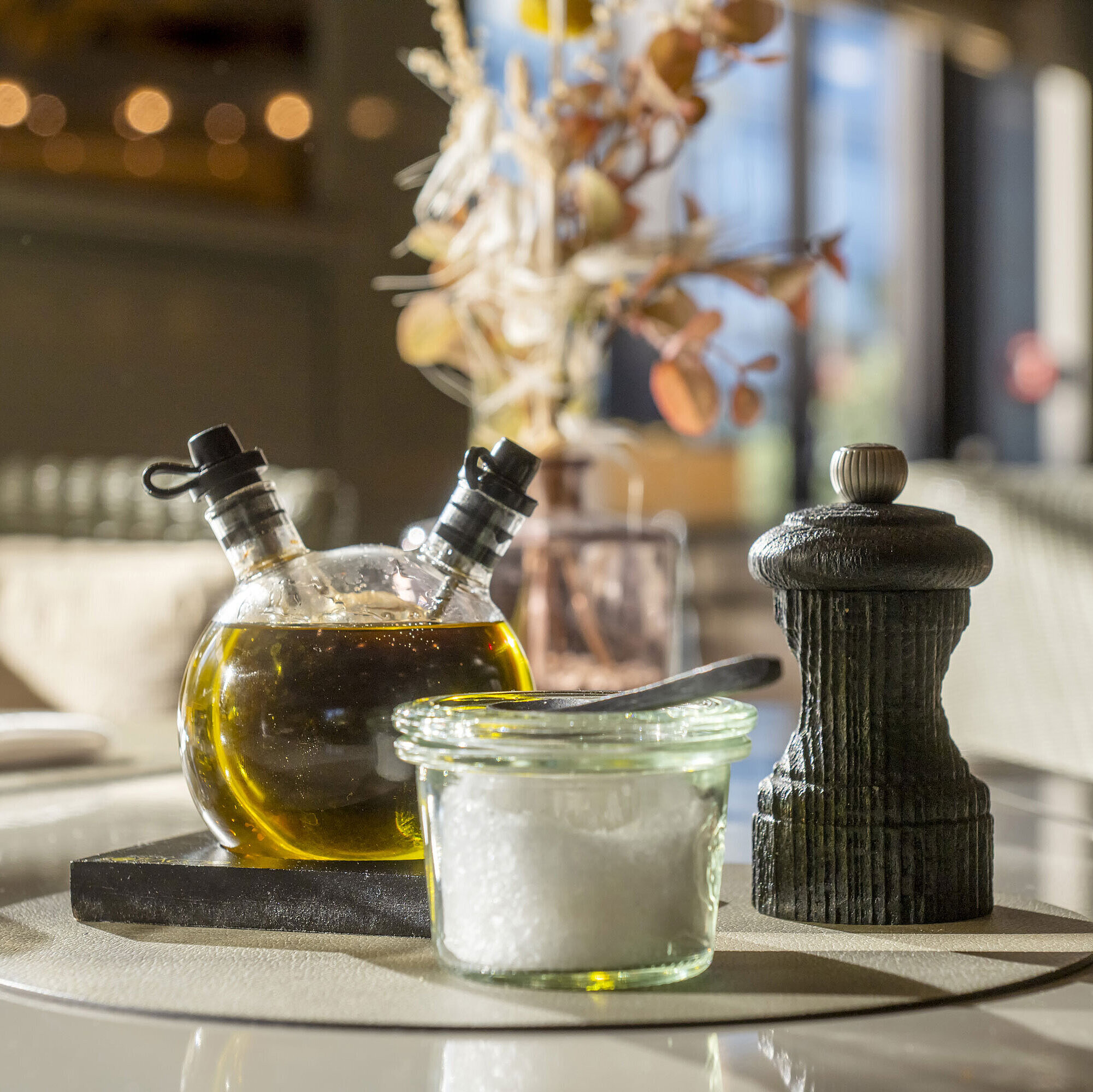 Restaurant detail Close-up of a set table at Maritim Hotel Düsseldorf with olive oil, salt, and pepper grinder.