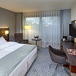 Modern superior double room at Maritim Hotel Bremen with seating area, desk, and large window for natural light.