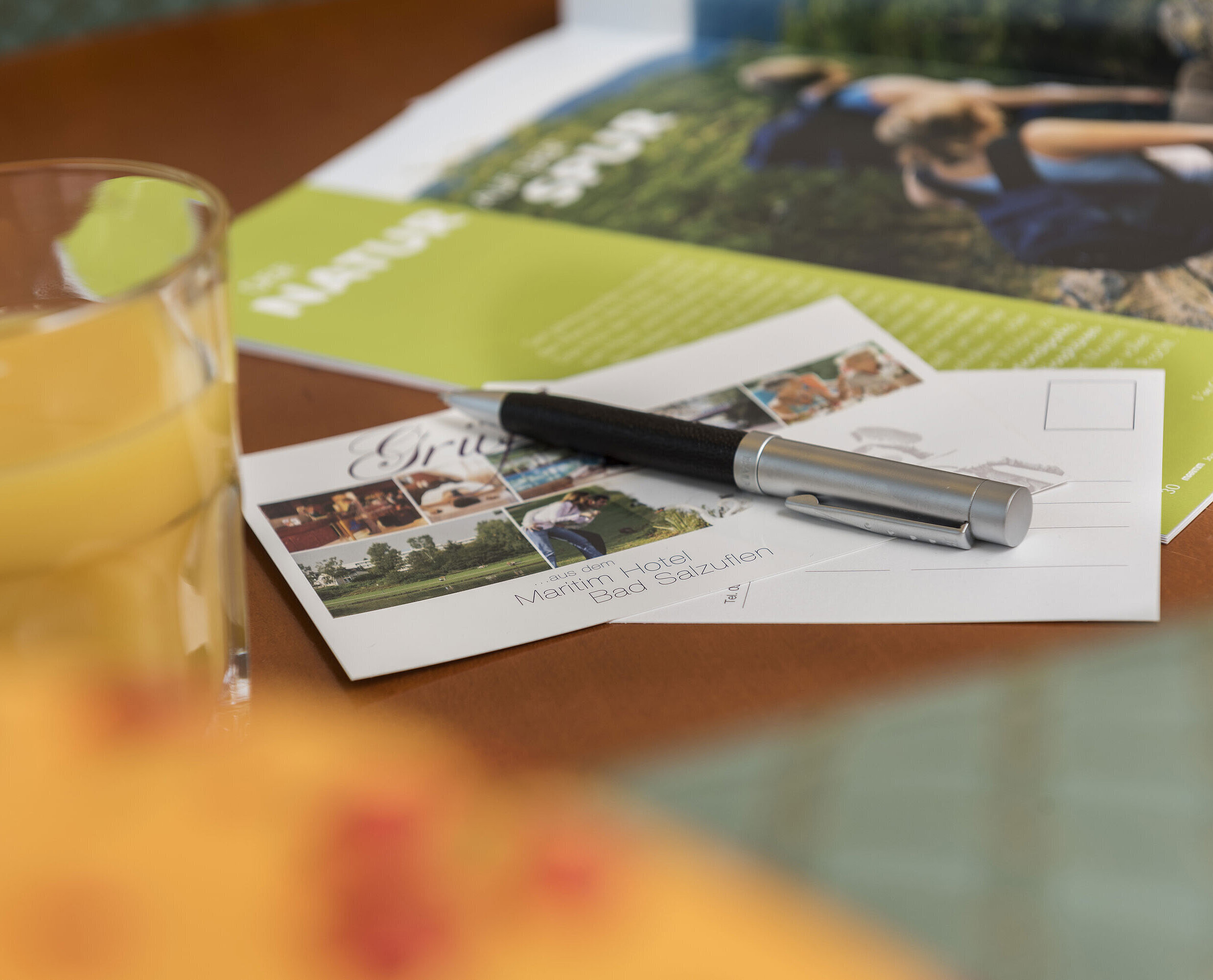 Detail of the hotel room Table with postcard from Maritim Hotel Bad Salzuflen, pen, juice and brochure