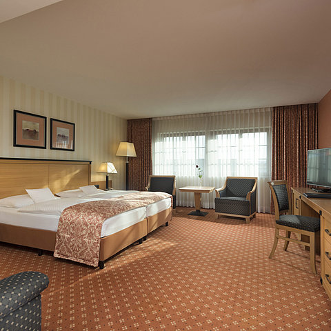 Classic room at Maritim Hotel Dresden with double bed, seating area, and classic decor.