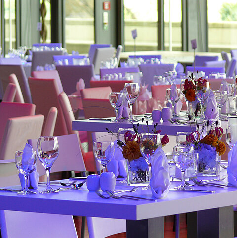 Close-up of elegantly set tables with floral arrangements in the event room at Maritim Hotel Dresden.