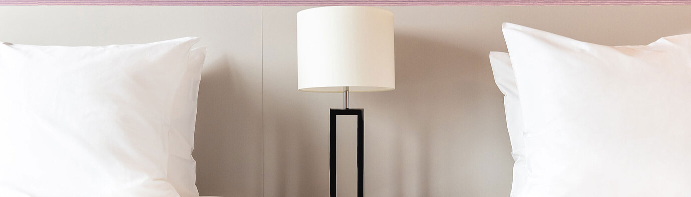 Bedside table with lamp between two beds in Maritim Hotel Amsterdam