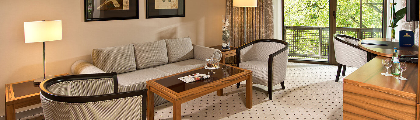 Cozy living area of the suite at Maritim Hotel Bad Homburg with elegant seating and balcony.