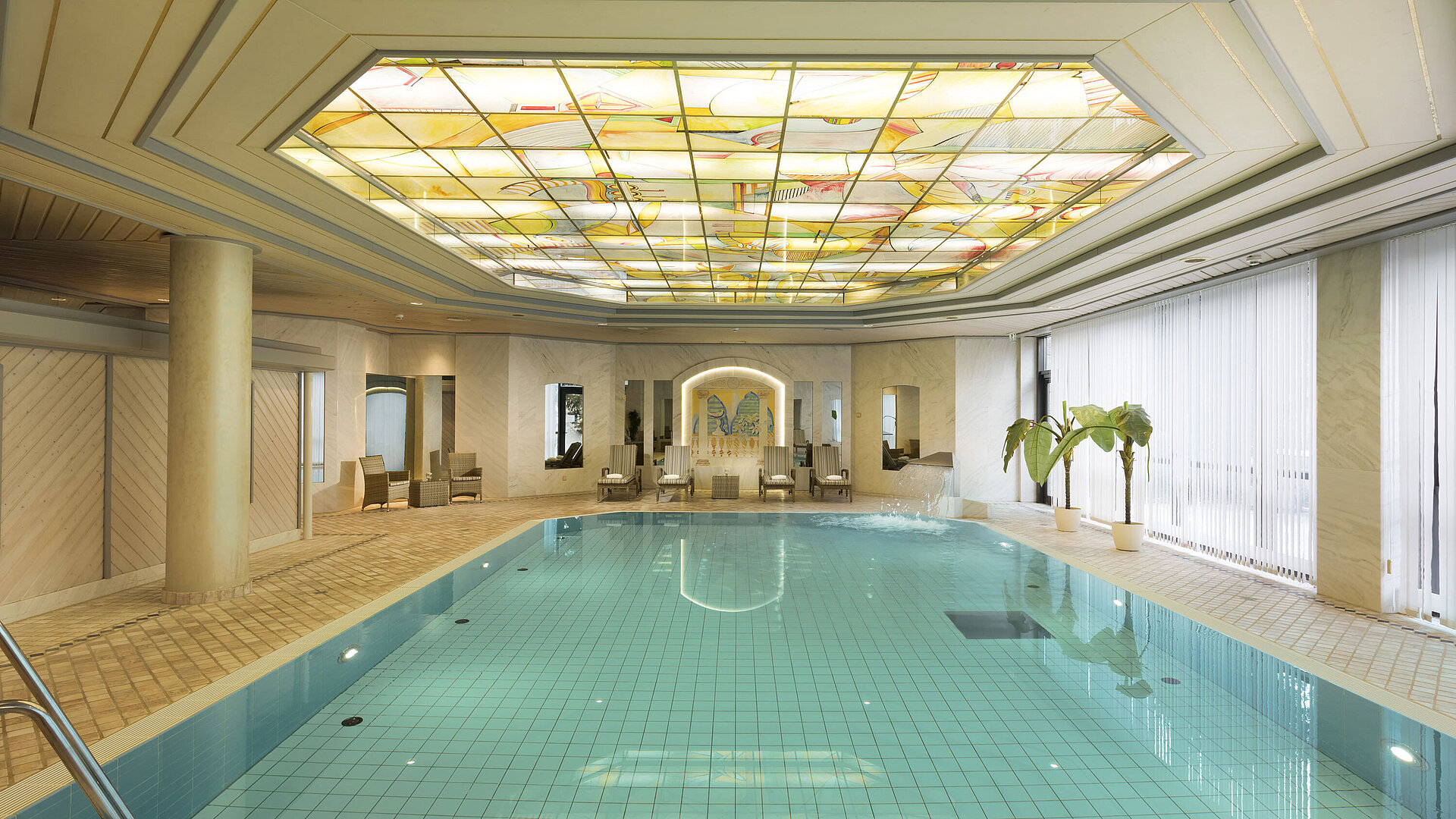 Pool Indoor pool with skylight and loungers at the wellness area of the Maritim Hotel Ulm