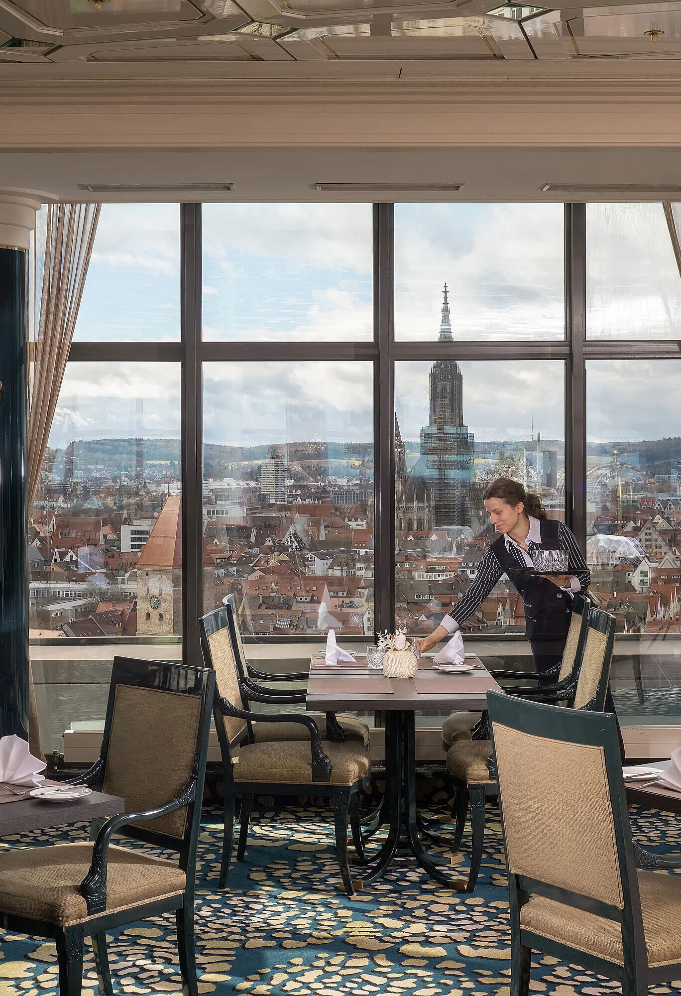 Restaurant in Maritim Hotel Ulm with set tables, large windows and views over Ulm with Ulm Minster