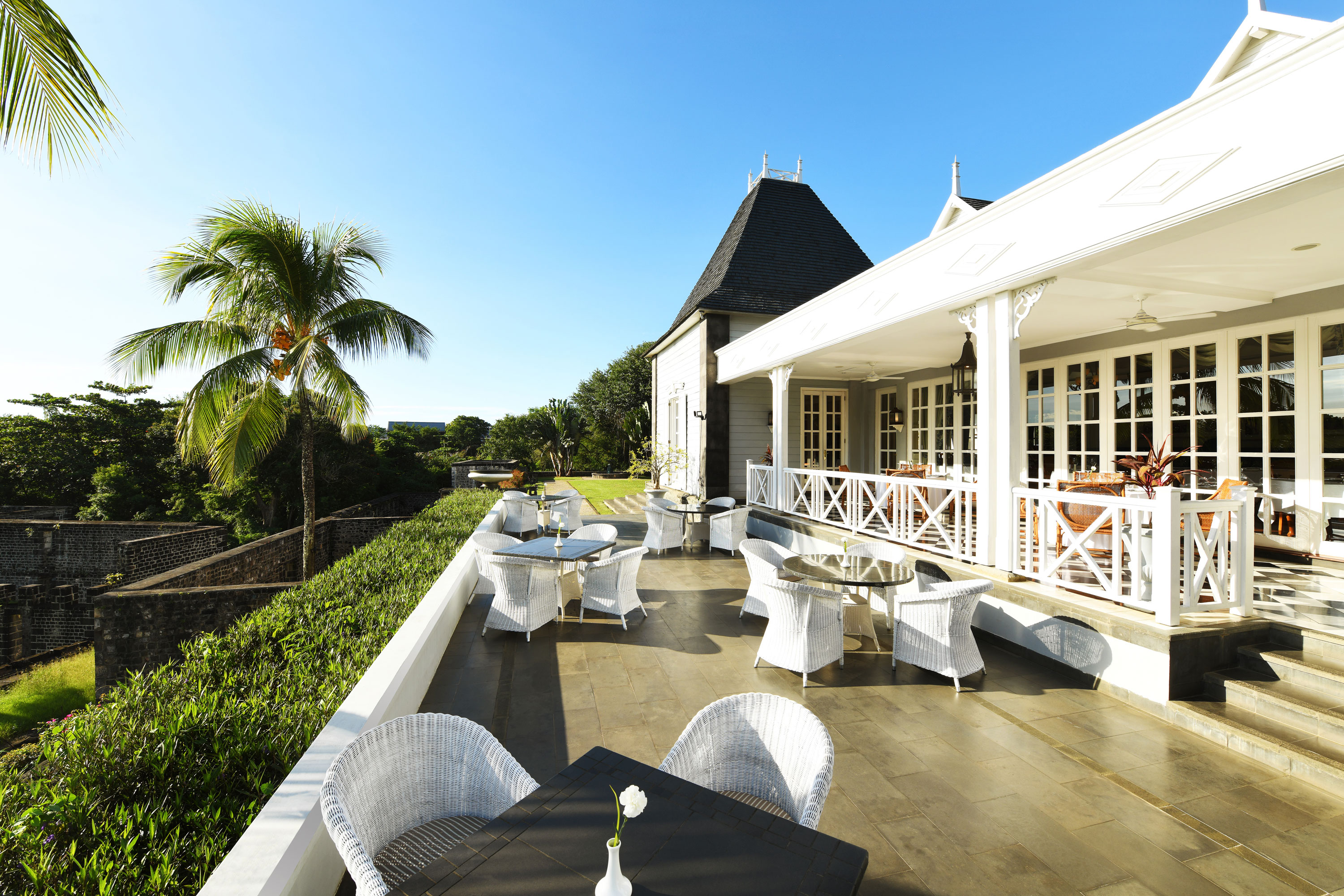"Château Mon Désir" event venue Terrace with stylish rattan furniture, overlooking the garden and the building in the background