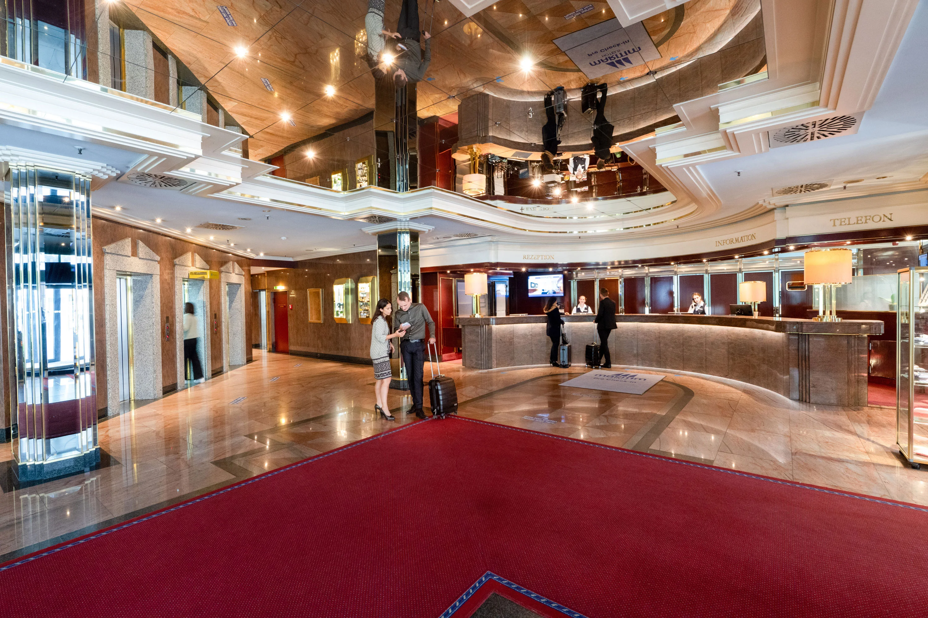 Reception Elegant hotel lobby with reception and guests checking in at the Maritim Hotel München.